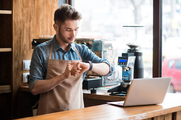 Pleasant waiter  sitting at the table 