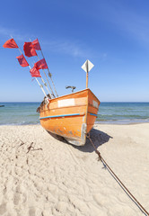Small fishing boat on a beach in Rewal, Poland.