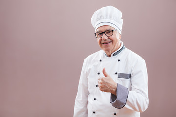 Portrait of happy restaurant's chef who is satisfied with his meal