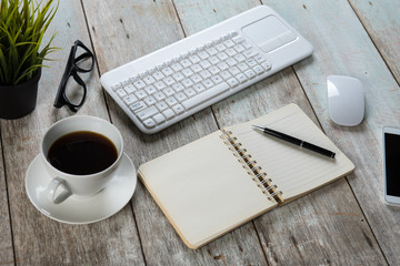 Mix of office supplies and gadgets on a wooden table background.