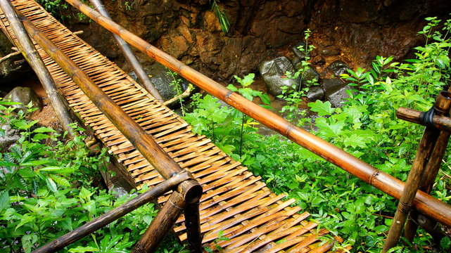 einfache geflochtene Bambusbr&uuml;cke &uuml;berspannt Bach im tropischen Regenwald