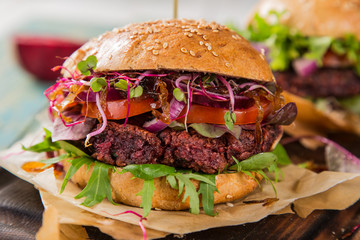 Tasty vegetarian beet burgers on wooden table.