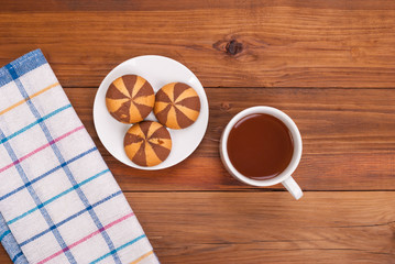 Tea and biscuits on a wooden table.