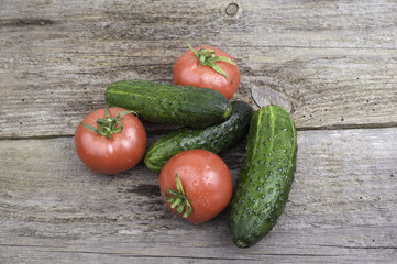 Tomatoes and cucumbers on wooden background