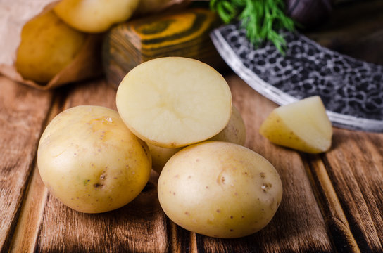 Fresh young potatoes on wooden background. Selective focus
