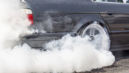 Drag racing car burns rubber off its tires in preparation for th