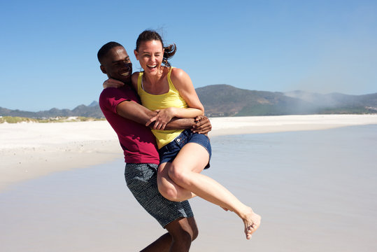 Playful young couple having fun outdoors on the beach