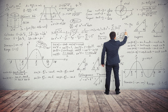 Man is writing solution of mathematical tasks on the wall