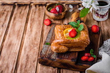 Freshly baked puff pastry with fruits and strawberries on wooden background. Selective focus. Top view