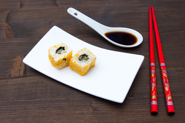 Fototapeta na wymiar California roll with salmon and mallotto eggs on a wooden table