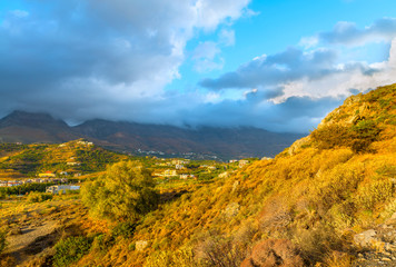 Beautiful sunset at the mountains of Crete island,next to Mediterranean village Plakias.Mountains is shrouded with clouds.Panoramic view.Scenic natural landscape.District of Rethymno.Greece.Europe.
