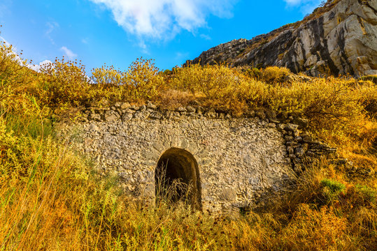 Beautiful view on  passage in the old picturesque wall, on a background of mountains. Touristic village of Plakias in the evening at sunset.Crete island. District of Rethymno. Greece. Europe.