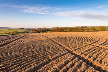 Obraz premium Spring rural countryside with ruts in plowed field
