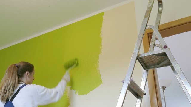 painter sweeps the walls with green paint