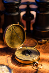 Old vintage retro compass and spyglass on ancient world map. Vintage still life. Travel geography navigation concept background.