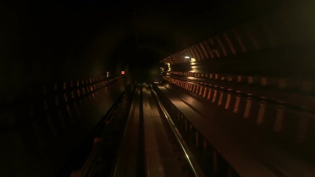 Camera Moves Backward along Metro Rails in Dark Tunnel