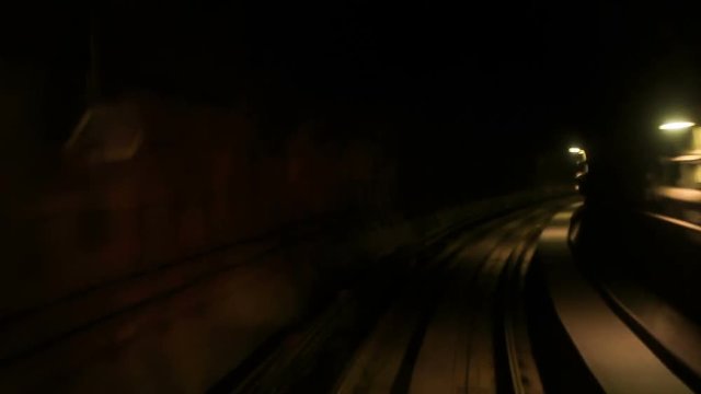 Camera Moves Forward along Metro Rails in Dark Tunnel