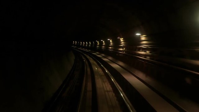 Camera Moves Backward along Metro Rails in Dark Tunnel
