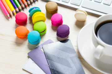 Credit card, keyboard and coffee cup, macaroon on a wooden table.