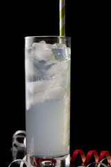 Collins glass with cocktails and colored straws.