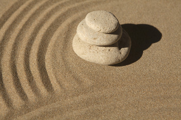Fototapeta na wymiar ondulation sur le sable et galets zen
