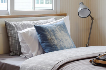 cozy bedroom interior with pillows and reading lamp on bedside table