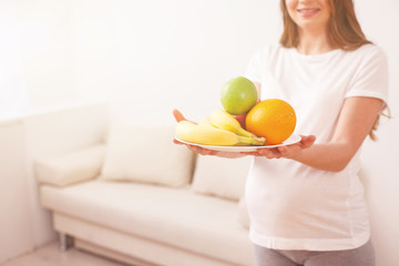 Cute pregnant woman is caring of her health
