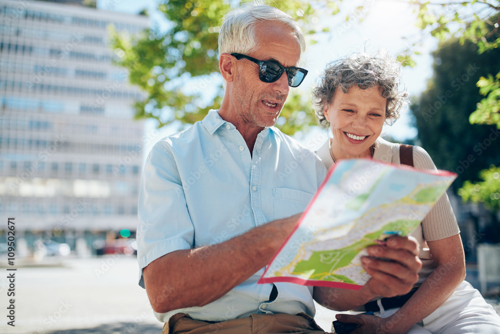 Wall mural senior couple looking at city map