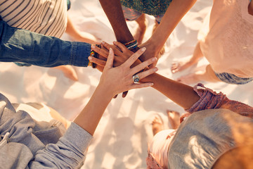 Hands of young people on stack at beach - Powered by Adobe