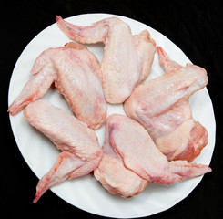Fresh chicken wings on a black background