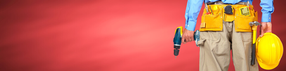 Construction worker with helmet and drill.