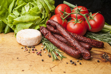 Fresh sausages and cheese on wooden desk