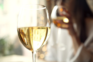 Woman drink white wine with friend in restaurant