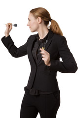 Confident businesswoman throwing dart