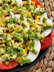 Healthy salad with tomatoes, raw mushrooms and avocado. Close up, vertical shot
