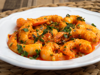 Pan fried shrimps with tomatoes, garlic and basil sauce. Low angle view.