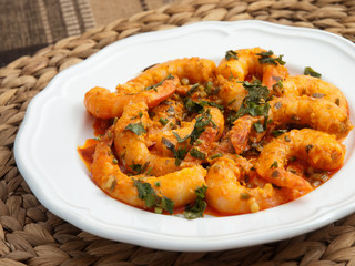 Pan fried shrimps with tomatoes, garlic and basil sauce. Close up