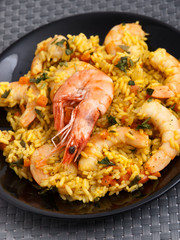 Seafood risotto with shrimps, curry and herbs. Vertical shot, tilted. Shot from above