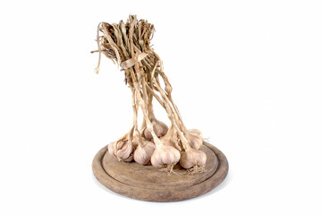 Bunch of garlic bulbs on a round wooden chopping board