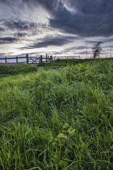 Beautiful English countryside landscape over fields at sunset
