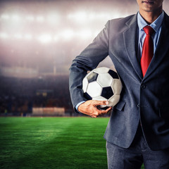 Naklejka premium soccer manager holding football in the stadium,closeup color process