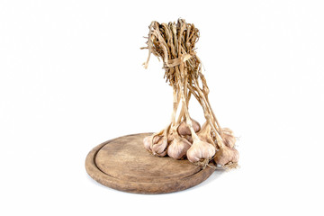 Bunch of garlic bulbs on round wooden chopping board