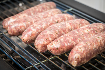 sausage cooking herbs on an electric bbq
