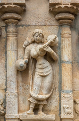 Trichy, India - October 15, 2013: Sandstone statue of musical woman with instruments at Ranganathar Temple. Outside wall of old part built during Madurai Nayak era. Traditional dress.