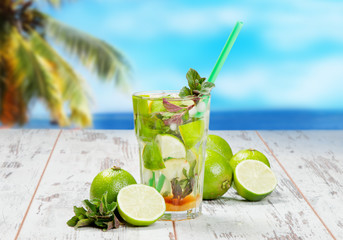 Mojito lime drink on wood with blur beach background