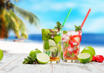 Mojito lime and strawberry drinks on wood with blur beach background