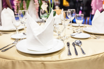 Close up white napkins folded on plates