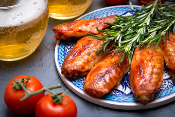 Fried chicken wings with beer on a dark gray background.