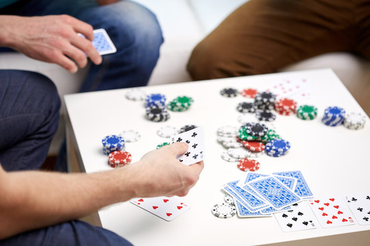 close up of male friends playing cards at home