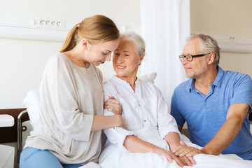 happy family visiting senior woman at hospital